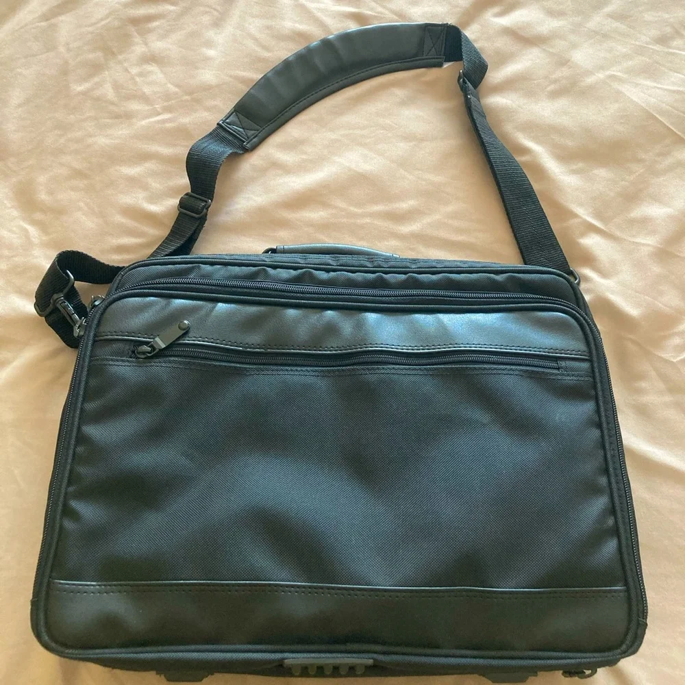 Gently used laptop bag in black nylon with several compartments.